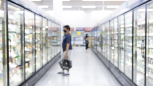 Two people shopping in fridge aisle of the supermarket
