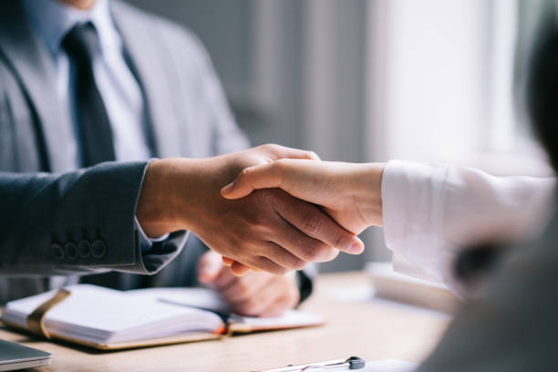 Two people shaking hands in a business meeting