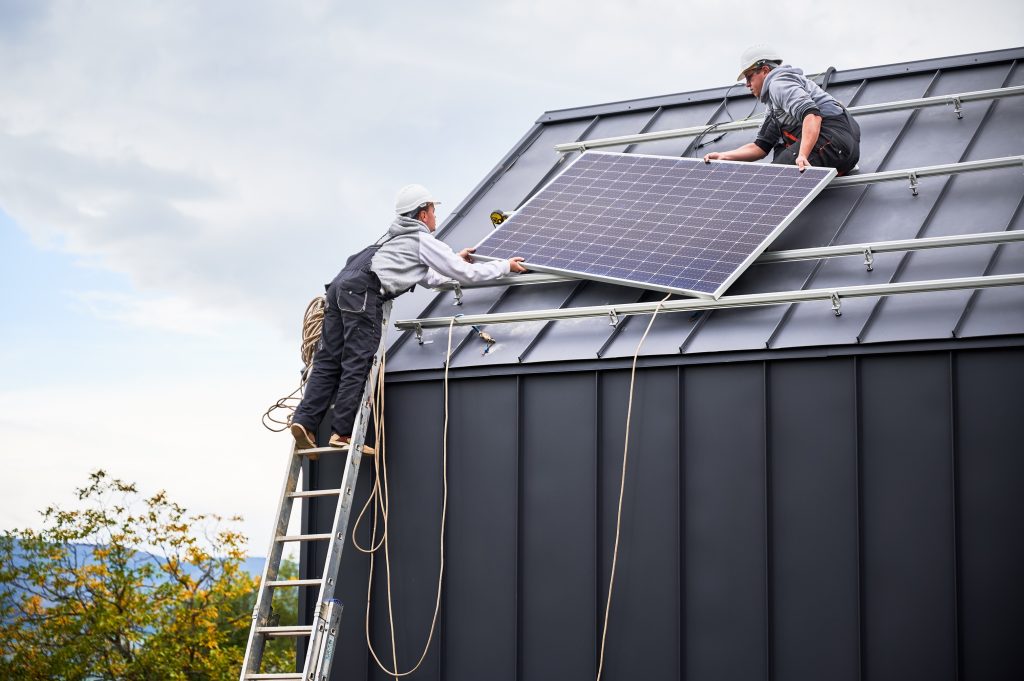 Technicians carrying photovoltaic solar module