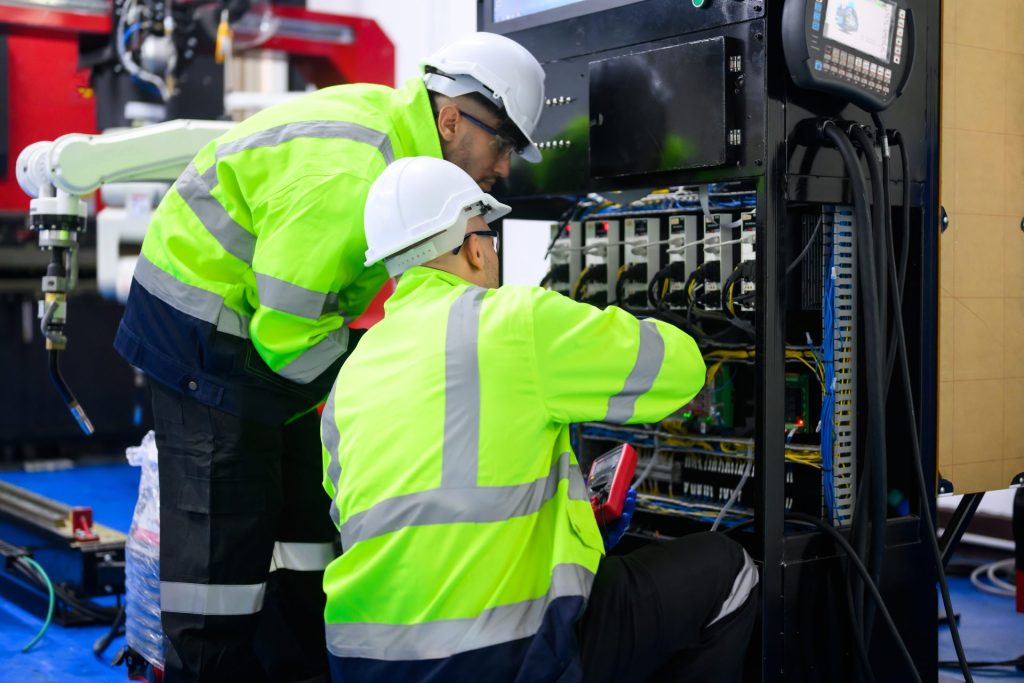 Two electricians at work in high-visibility jackets