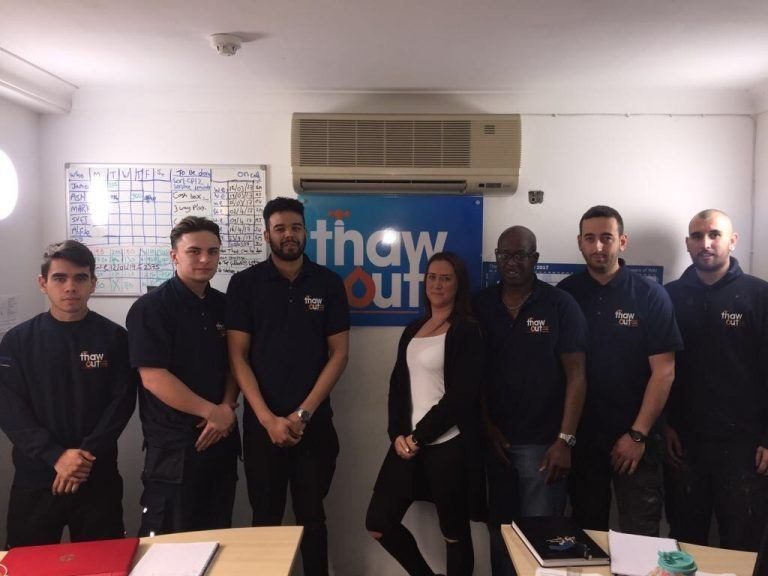 Thaw Out team members stood in front of their logo